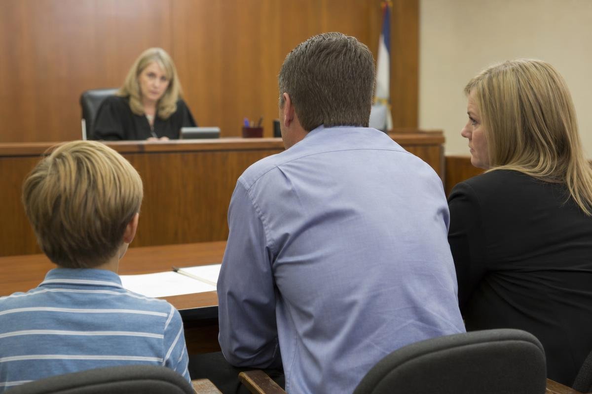 Parents and child seated before a judge during a family court hearing